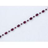 Bracelet articulé en or gris 750 millièmes, orné d'une ligne de rubis ovales [...]