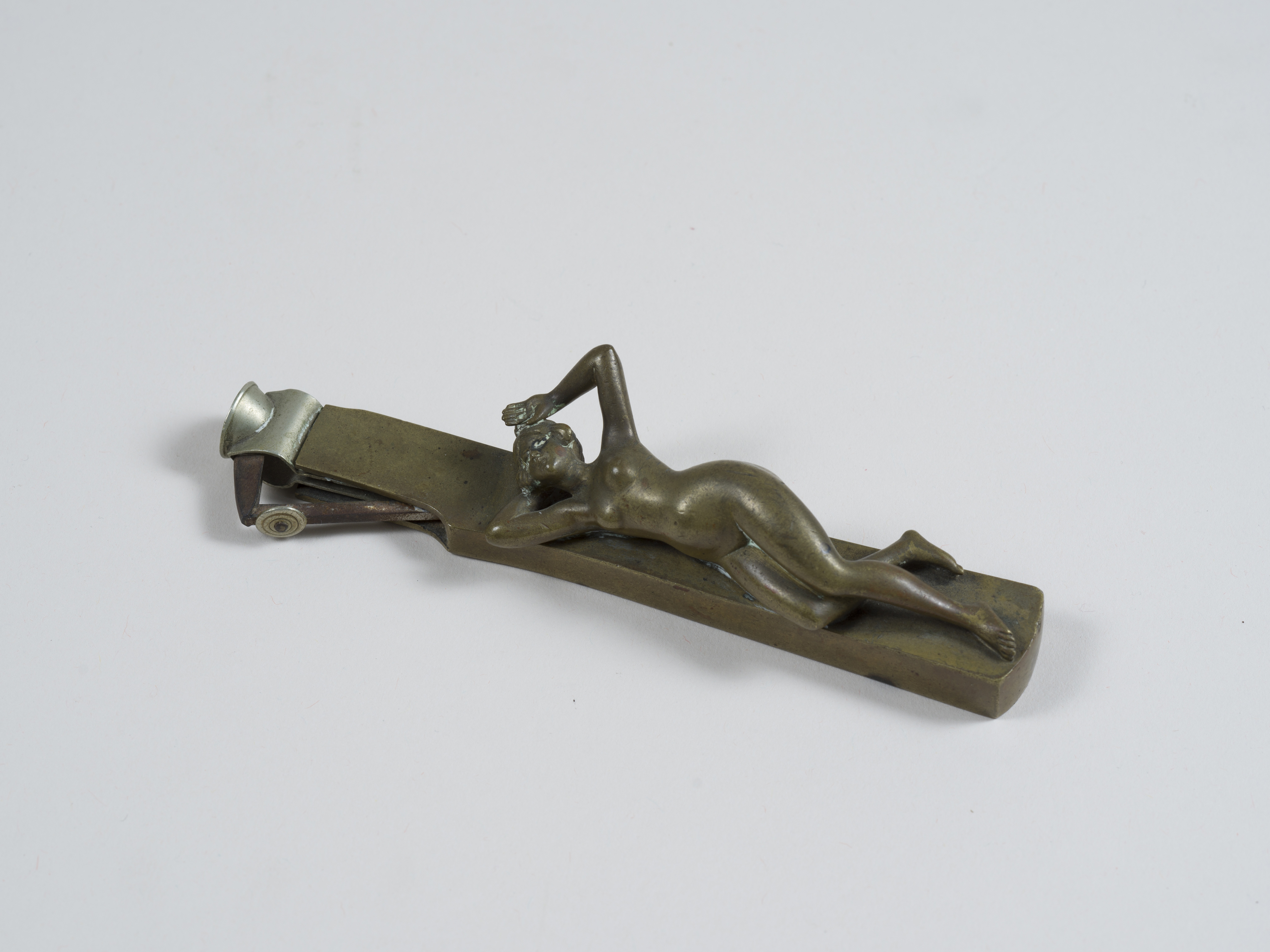 Erotica - Coupe cigare en bronze figurant une jeune femme nue allongée les bras [...]