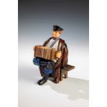 A realistically carved hardstone figure of an accordian player. In the manner of Fabergé,2nd half of