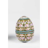 A silver-gilt and guilloche-enamel egg. 20th century. Ovoide body with polychrome enamelflowers on