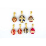 Seven silver-gilt and enamel egg-pendants. Modern. Ovoid body decorated with translucidenamel.