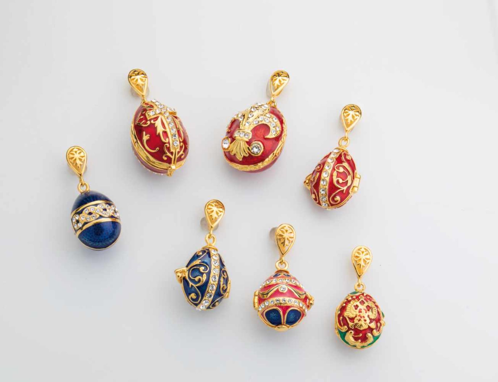 Seven silver-gilt and enamel egg-pendants. Modern. Ovoid body decorated with translucidenamel.