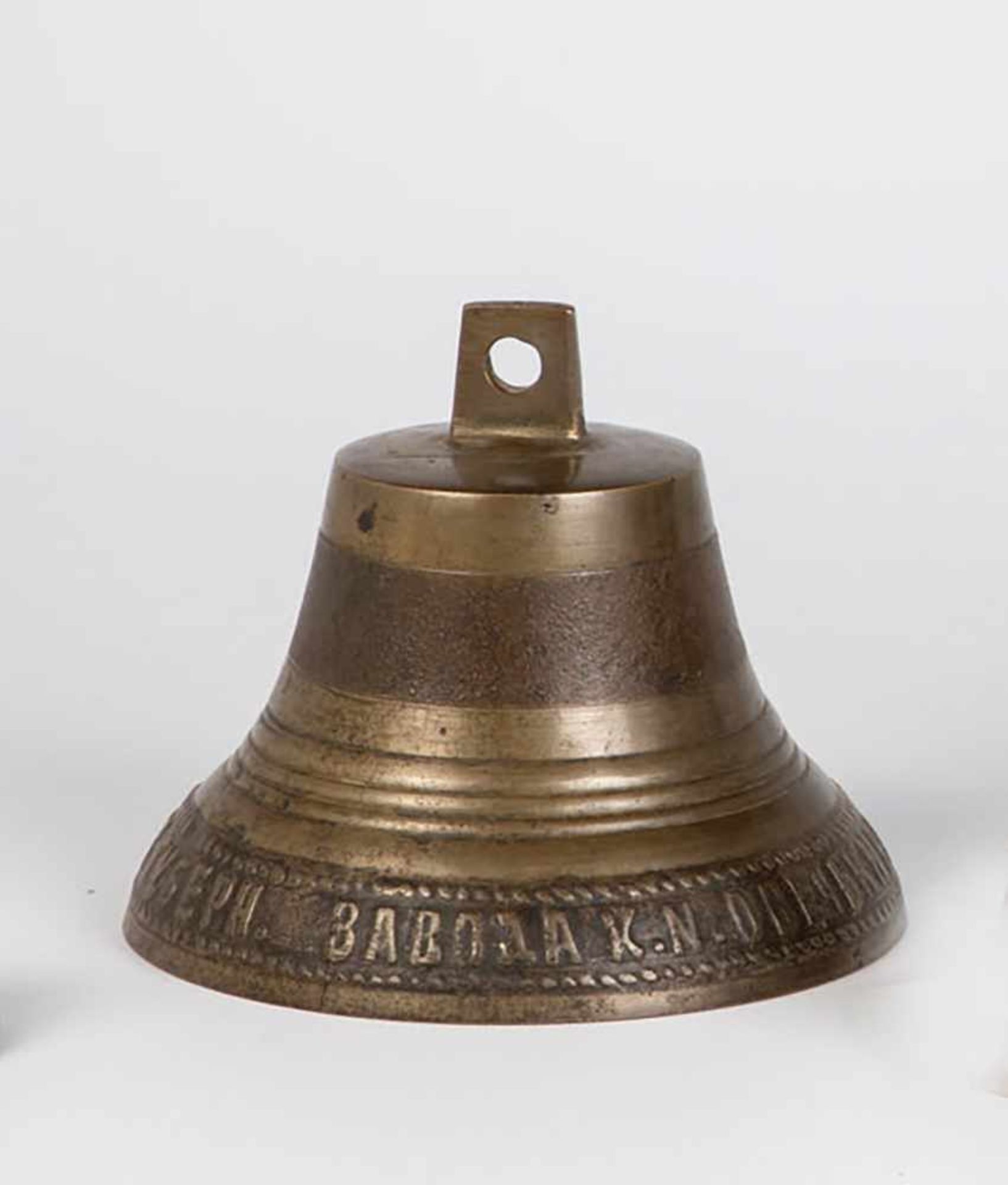 A bronze bell. Russia, early 20th century. Border with cyrillic insription in relief.Vertical crack.