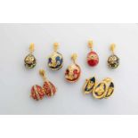 Seven silver-gilt and enamel egg-pendants. Modern. Ovoid body decorated with translucidenamel.