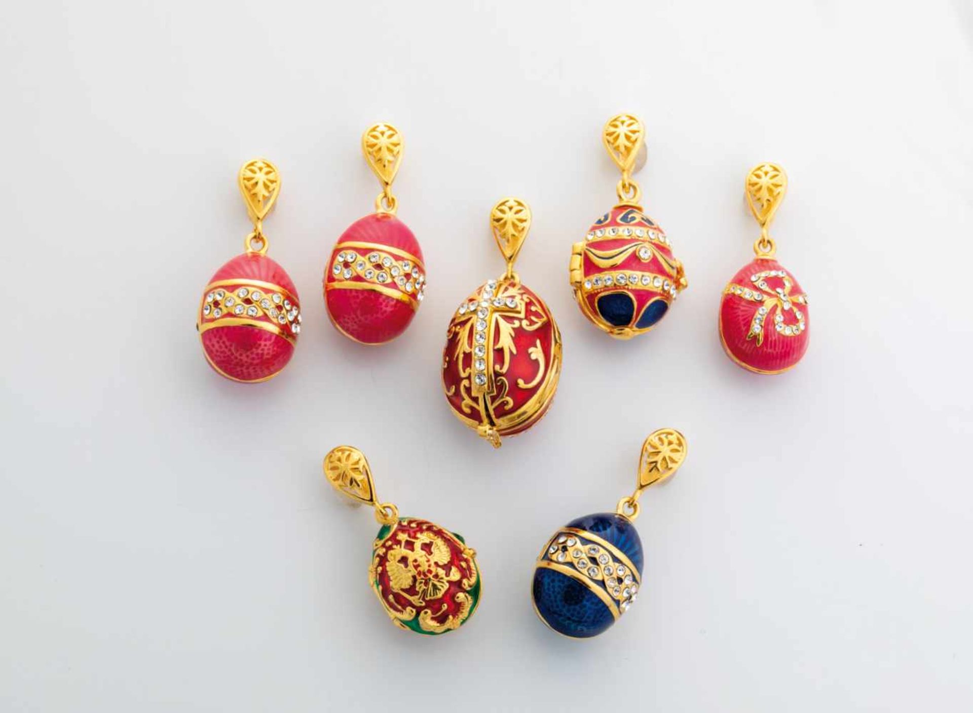 Seven silver-gilt and enamel egg-pendants. Modern. Ovoid body decorated with translucidenamel. Three