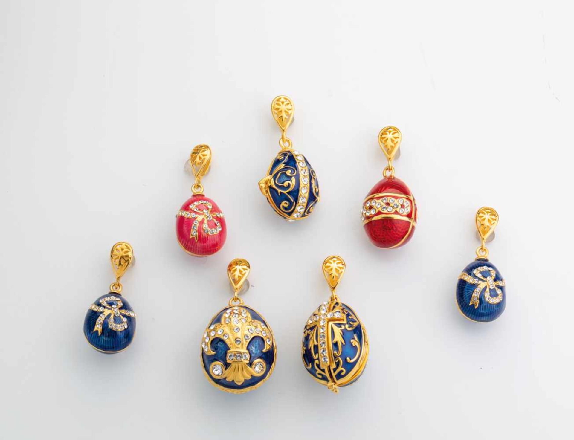 Seven silver-gilt and enamel egg-pendants. Modern. Ovoid body decorated with translucidenamel. Two