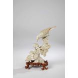 Bird sitting on a branch. China, 20th century. Jade on a wood base. 23.5 cm high(including the