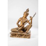 Sitar player. Thailand, early 20th century. Apsara sitting on a plinth playing Sitar,finely