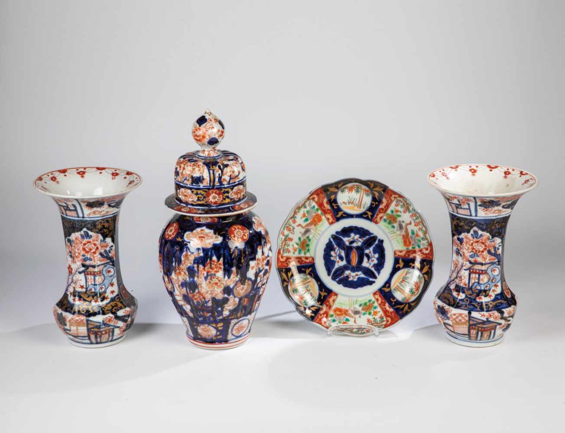 Convolute four parts Imari porcelain. Japan, 19th century. Consisting of a plate, a liddedvase and