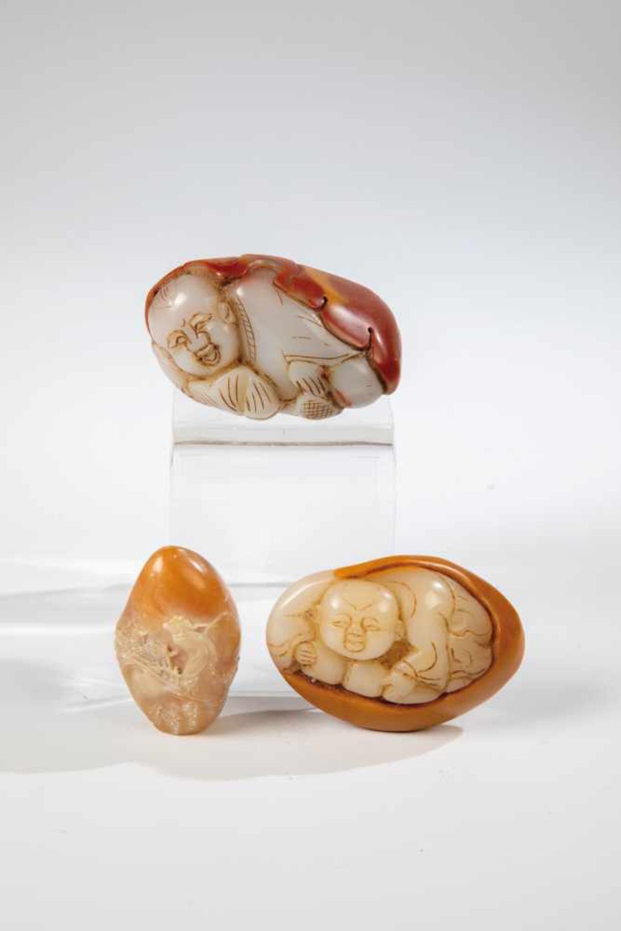 Three jade carvings. China, Qing Dynasty, 19th century. Ovoide forms with two figurativecarvings and