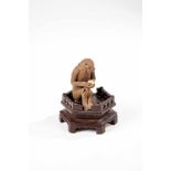 Netsuke monkey on a base. Japan, probably Taisho period (1912-1926). Sitting monkeyholding a