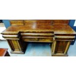 Early 19th century mahogany pedestal sideboard, with breakfront top over three drawers with carved