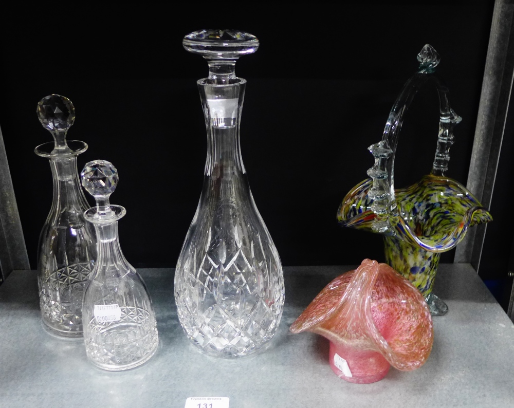 A group of three decanters with stoppers to include one by Webb and two coloured glass posy baskets,