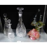 A group of three decanters with stoppers to include one by Webb and two coloured glass posy baskets,