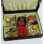 An embroidered box containing a quantity of vintage costume jewellery to include brooches, earrings,