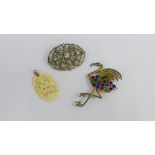 Vintage costume jewellery to include two paste set brooches and a carved bone pendant (3)