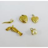 Three 9 carat gold pendants to include horn of plenty, heart locket and a pistol together with a