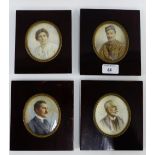 A family group of four early 20th century portrait miniatures, each contained within glazed mahogany