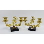 Pair of gilt brass candlesticks on square hardstone bases, 26cm wide, (2)