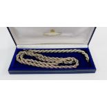 Silver rope twist necklace intertwined in a gilt metal trace link chain together with matching