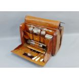 Leather Gladstone style bag containing glass and Epns topped toilet bottles, jars etc., (a lot)