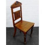 Oak hall chair, the arched top rial over a carved back above a solid seat, with turned legs, 100 x