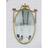 Oval giltwood framed wall mirror surmounted by an urn motif