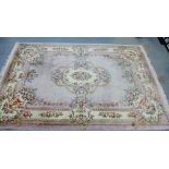 Large Chinese wool rug, the pale pink field with central floral medallions, within flowerhead