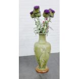 Large celadon green glazed vase with water lily pattern, containing a collection of artificial