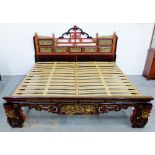 Chinoiserie bed, the black and red lacquered head and foot boards elaborately carved and gilded with