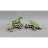 Two green jadeite carved horse figures on shaped hardwood stands, longest 13cm, (one a/f),(2)