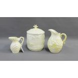Three items of Belleek porcelain to include two jugs and a shell moulded biscuit jar and cover,