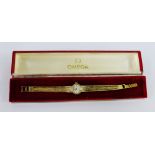 Lady's 9 carat gold Omega wristwatch on a textured 9 carat gold bracelet strap, complete with