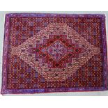 Eastern rug/mat with central diamond lozenge to a blue and red field, 77 x 100cm