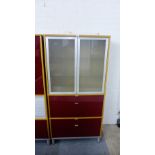 Modern bookcase cabinet, with a pair of opaque glass doors over four dark red vinyl drawers, on