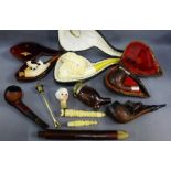 A collection of pipes to include two Meerschaum in leather cases and a black forest style pipe,