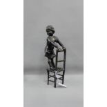 Bronze figure of a young girl standing upon a chair, 28cm high