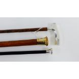 Two Early 20th century silver mounted walking canes together with another with yellow metal