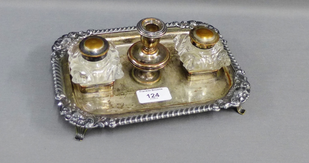 Epns on copper desk ink stand with candlestick to centre, flanked by two moulded glass inkwells