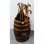 Oak and brass bound barrel with painted crest, together with a collection of walking sticks, canes