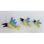 Hannah Turner group of three painted pottery flying wall birds of graduating size, signed and