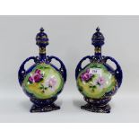 Pair of continental porcelain twin handled vases with covers with floral sprays and a blue ground,