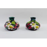 Pair of Moorcroft baluster floral patterned vases with a blue ground with printed and impressed