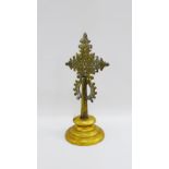 Brass pierced cross sculpture on a circular gilt wood base, 37cm high