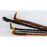 A collection of four Gentleman's wooden walking canes together with a horn handled swagger stick,