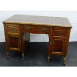 Mahogany desk with inset red leather skivver above a central frieze drawer flanked by two cupboard