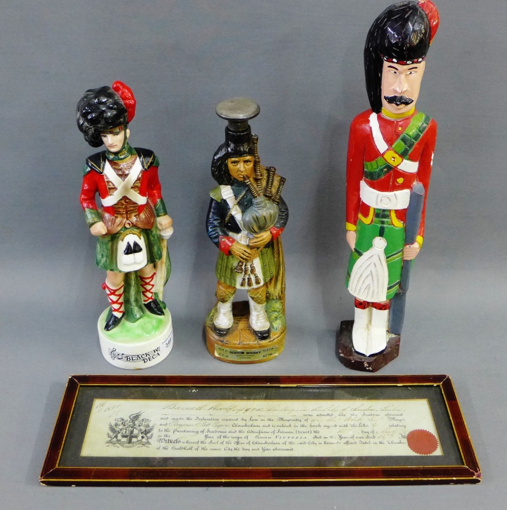 Novelty Piper whisky decanters and a painted wooden figure, together with a framed Victorian