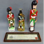 Novelty Piper whisky decanters and a painted wooden figure, together with a framed Victorian