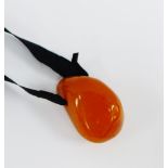 Amber pendant on a black ribbon, approx 50 grams