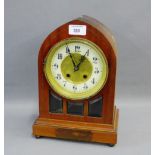 Mahogany cased mantle clock with arched top over circular dial with Arabic numerals to the chapter